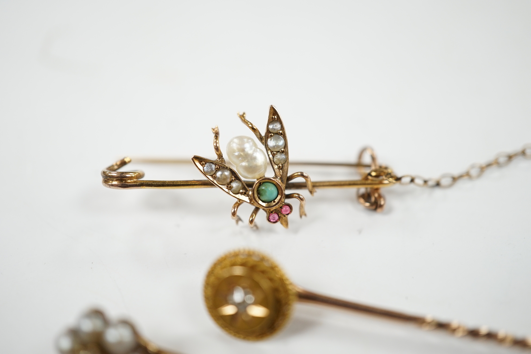 An early 20th century 9ct and gem set bug brooch, 34mm and two yellow metal stick pins, diamond and diamond and seed pearl set.